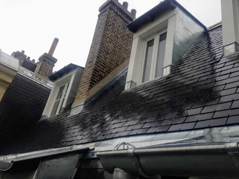 Toiture en ardoise naturelle avec lucarnes, souches de cheminée en brique et zinguerie
